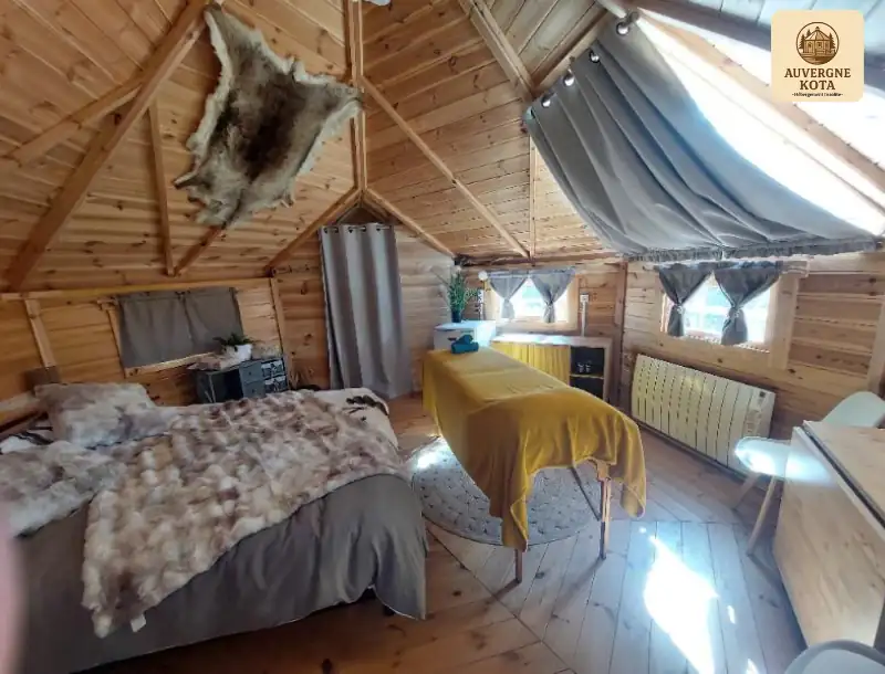 Intérieur cosy du kota finlandais tout équipé avec table de massage partenaire Shakti l’Éveil des Sens-Auvergne Kota-hébergement insolite-logement insolite-séjour détente-escapade nature-location-vacances-Bain nordique privatif-week end romantique-Brugheas-Vichy-Allier-Clermont Ferrand-2